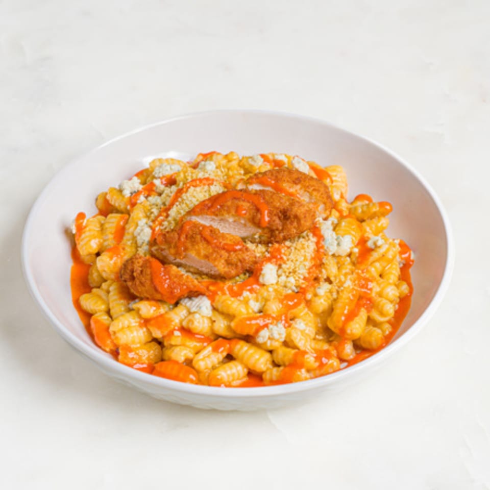 A'mano Fresh Pasta Kitchen's Buffalo Chicken Gnocchi, featuring crispy chicken, spicy sauce, and blue cheese crumbles.