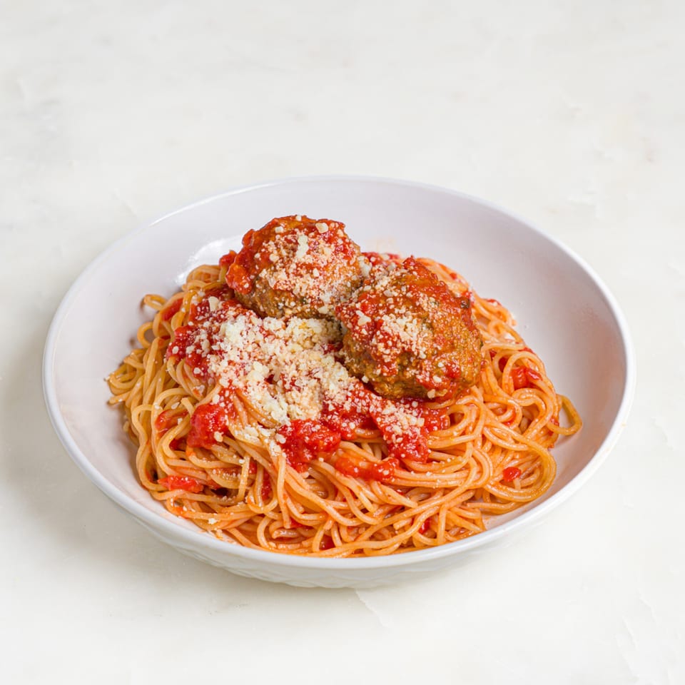 A'mano Fresh Pasta Kitchen's spaghetti and meatballs, topped with rich red sauce and grated cheese.